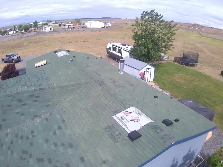 Worn green shingle roof before replacement