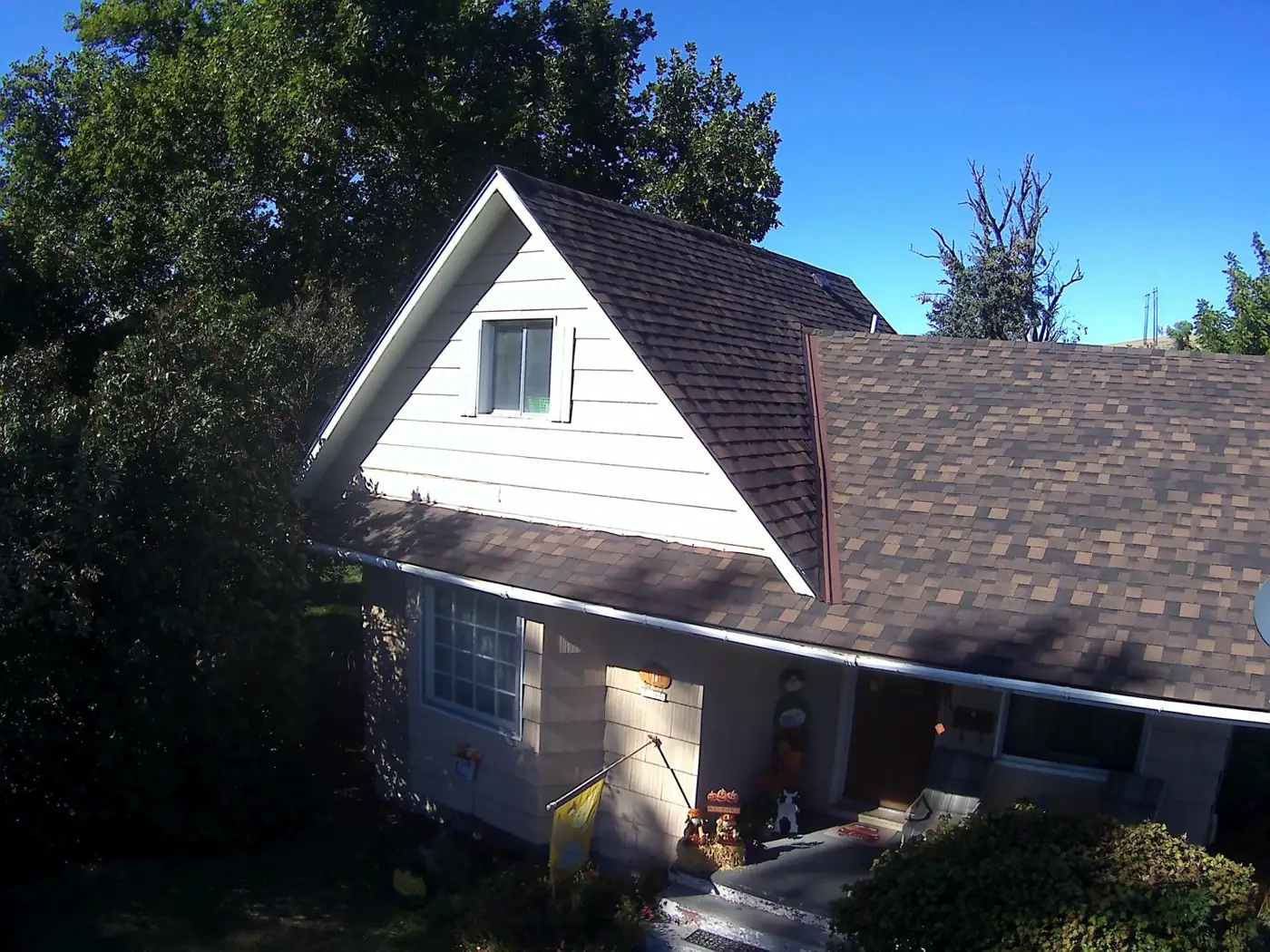Two-story home with brown shingle roof